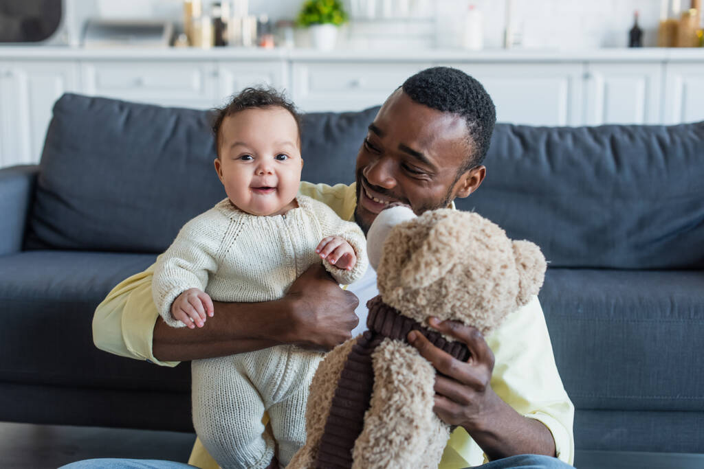 onnellinen isä tilalla iloinen afrikkalainen amerikkalainen vauva tyttö ja nallekarhu - Valokuva, kuva