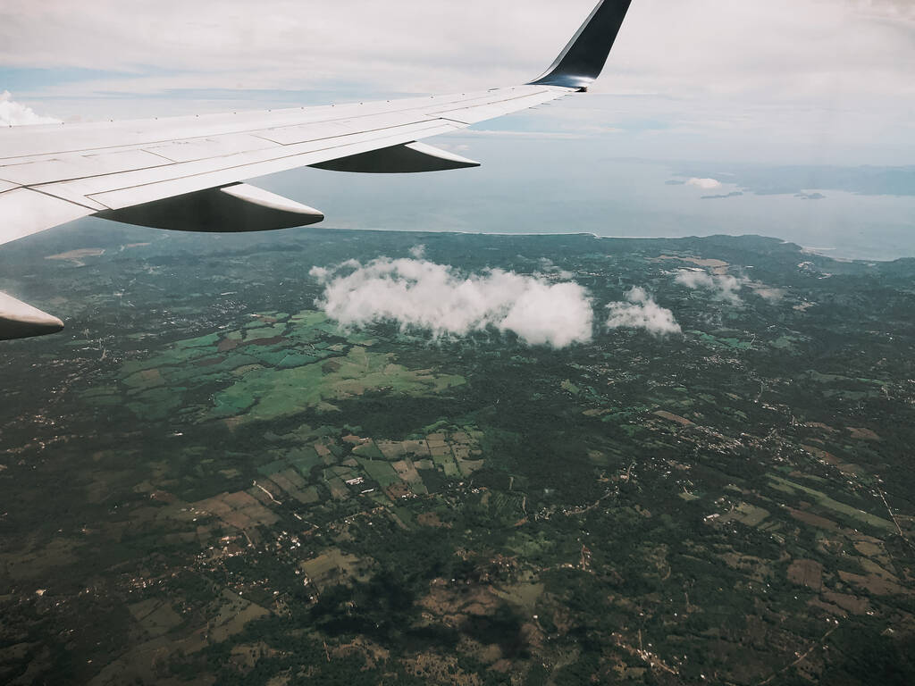 Piękny widok na samolot z chmurami i krajobrazem - Zdjęcie, obraz