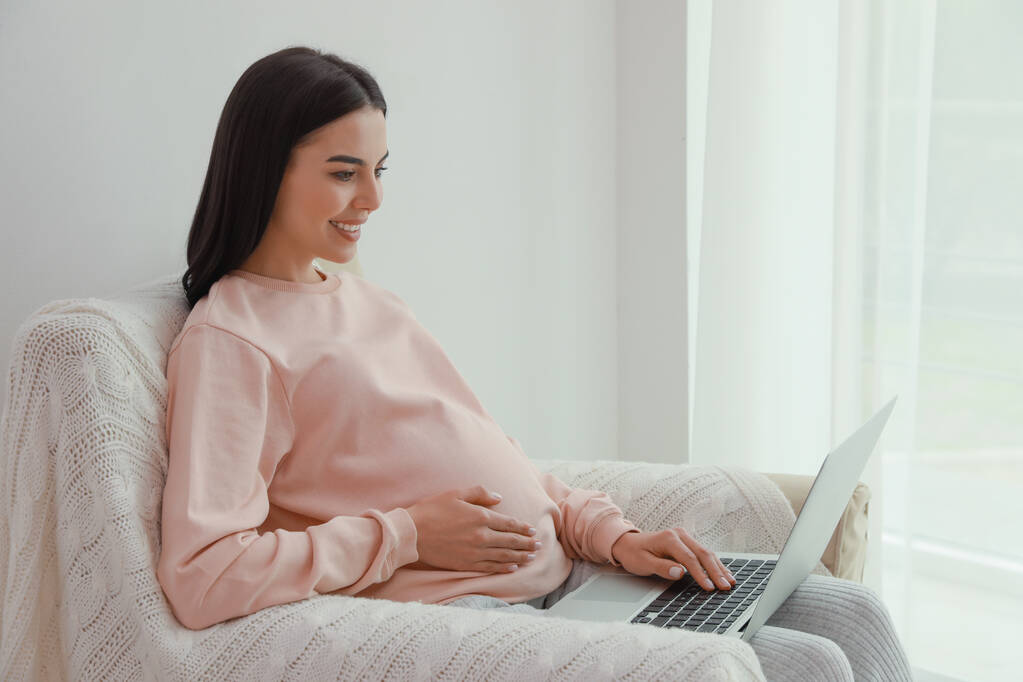 Jovem grávida com laptop em casa, espaço para texto - Foto, Imagem
