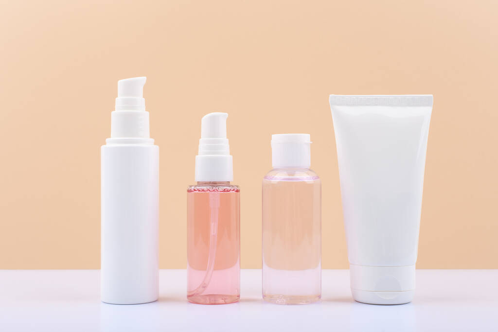 Set di bottiglie cosmetiche per la cura quotidiana della pelle di routine contro sfondo beige chiaro.  - Foto, immagini