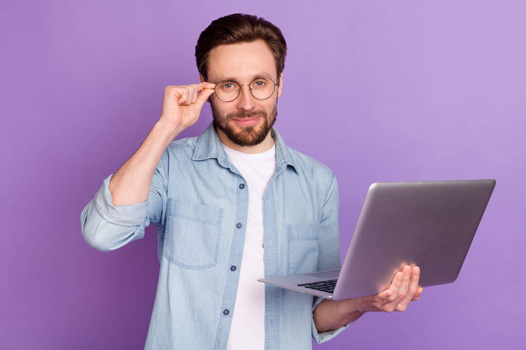 Fénykép a vonzó bájos fiatalember tartja számítógép viselet szemüveg okos srác elszigetelt lila színű háttér - Fotó, kép
