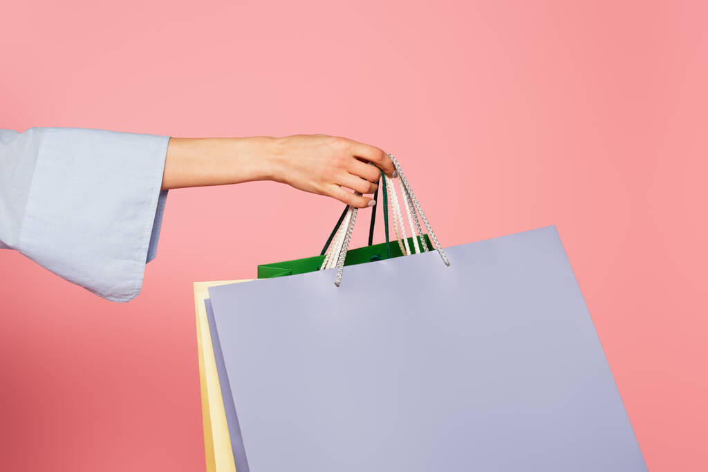 Vágott kilátás nő gazdaság bevásárló táskák elszigetelt rózsaszín  - Fotó, kép