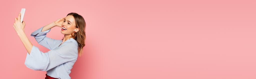 Radosna kobieta w słuchawce, dzwoniąca na komórkę na różowym tle, baner  - Zdjęcie, obraz
