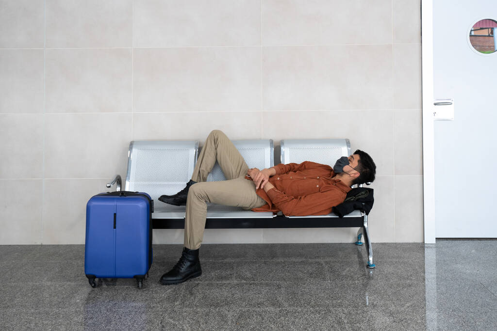 Lähikuva henkilöstä, jolla on kasvonaamio lentokentällä odottamassa lentoa - uusi normaali käsite - Valokuva, kuva