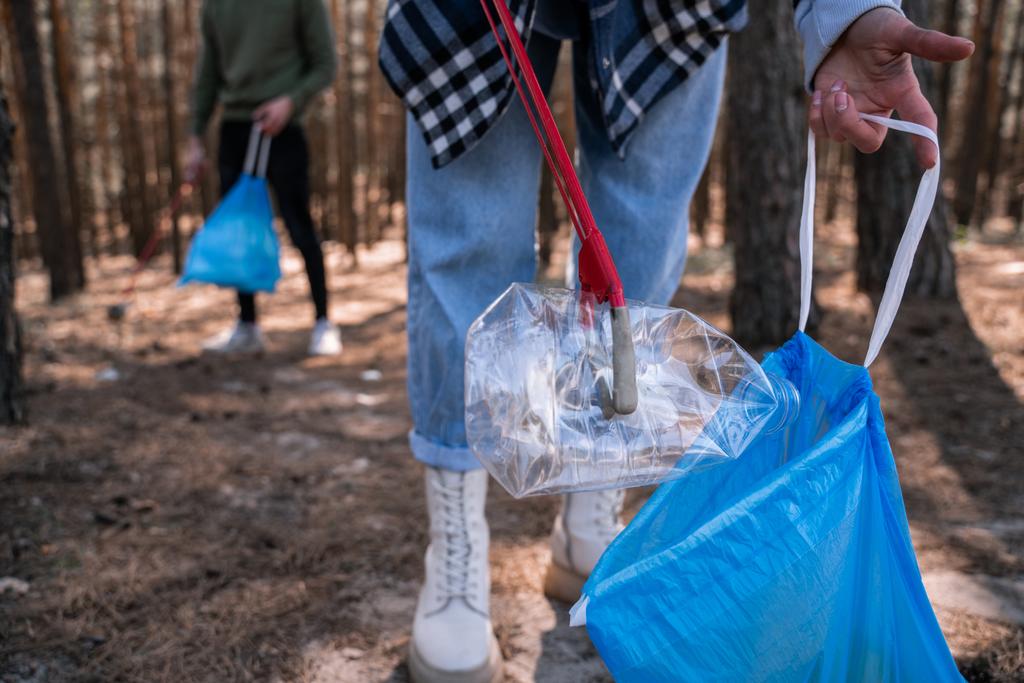 vista recortada de voluntarios recogiendo basura en el bosque - Foto, imagen