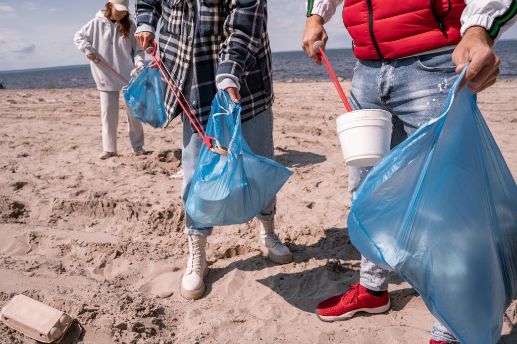 volontari che raccolgono rifiuti nei sacchi della spazzatura  - Foto, immagini