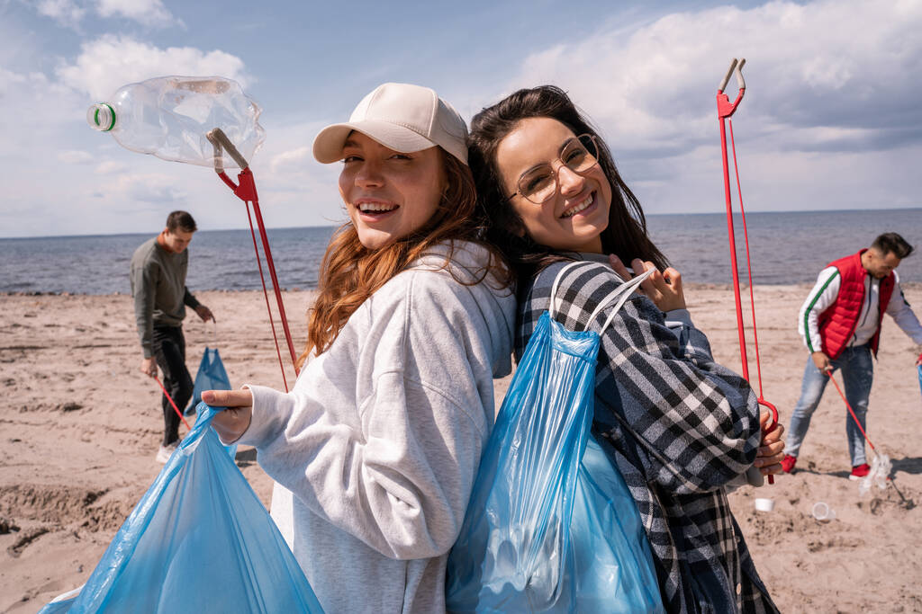 Kapkaçları ve çöp torbalarıyla mutlu genç kadınlar.  - Fotoğraf, Görsel