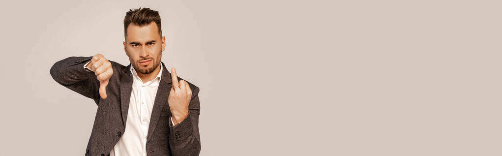 незадоволений чоловік, що демонструє нелюбовний знак і палець з обручкою ізольовано на сірому, банер
 - Фото, зображення