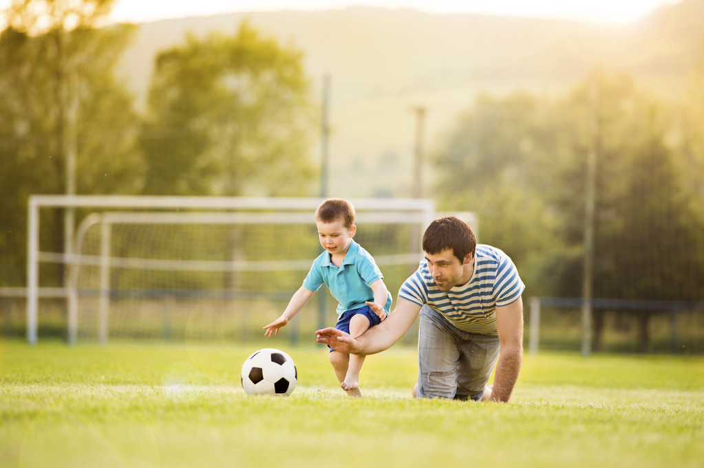 Padre con hijo jugando fútbol
 - Foto, imagen