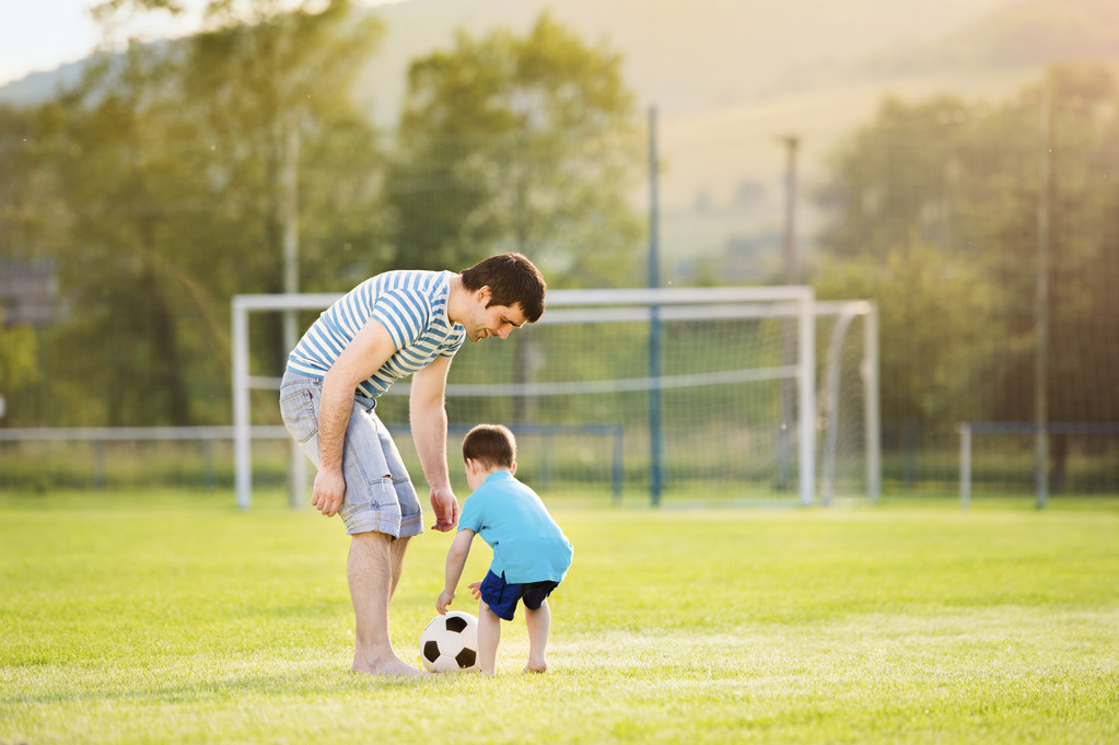 Padre con hijo jugando fútbol
 - Foto, Imagen