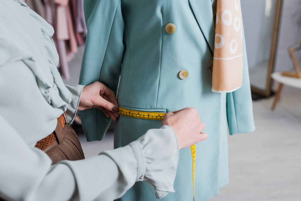 Cropped view of seamstress measuring pocket of blazer in atelier  - Photo, Image