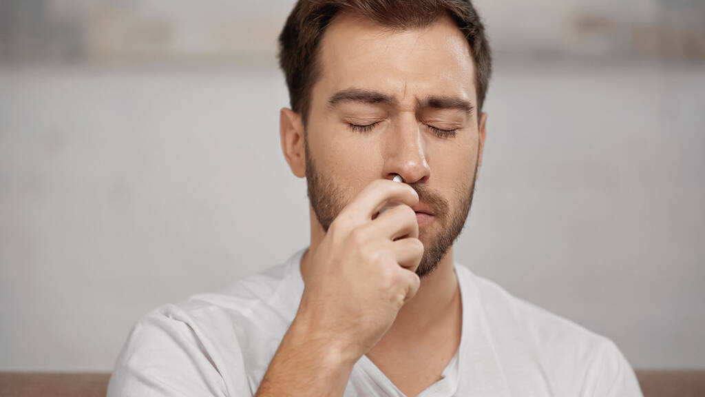allergic man using nasal spray at home  - Valokuva, kuva