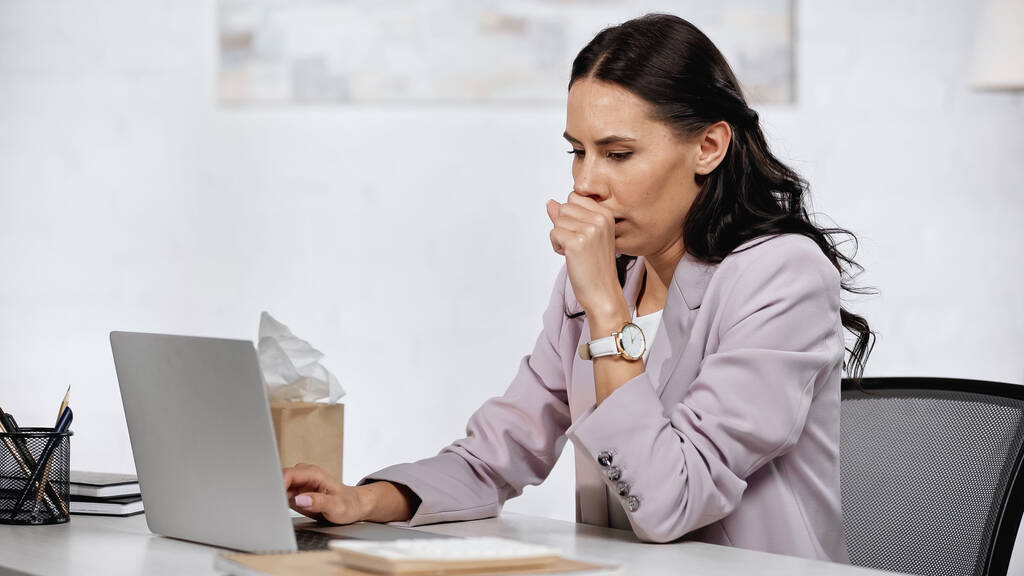 allergic businesswoman couching near laptop on desk - Zdjęcie, obraz