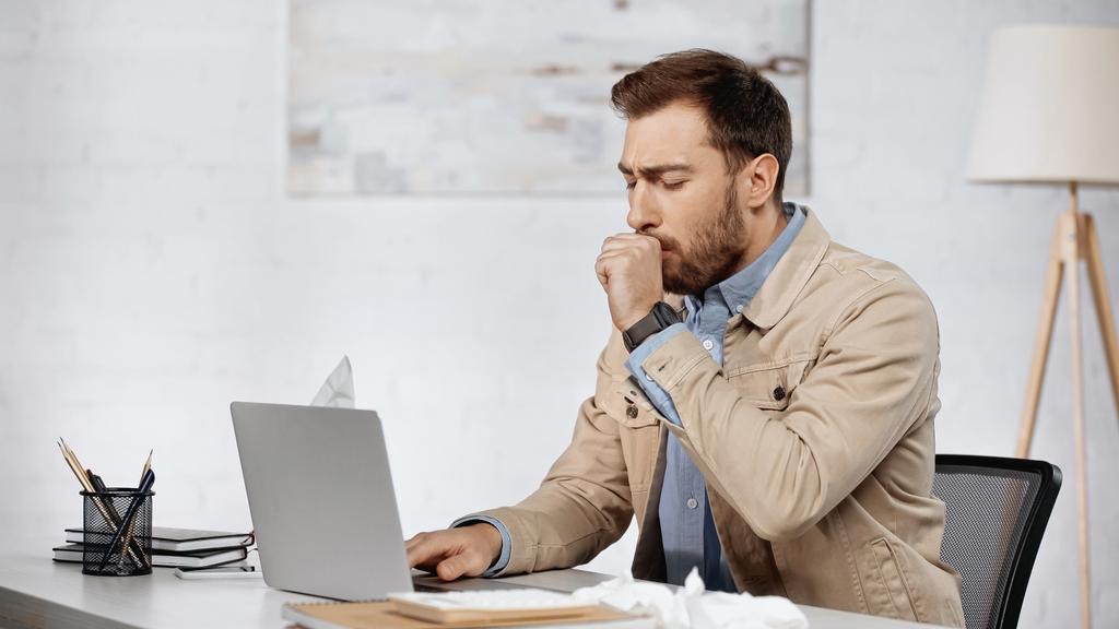 allergic businessman couching near laptop on desk  - Photo, Image