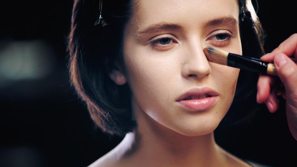 Make-up Artist trägt Make-up Foundation auf die Haut des Modells mit kosmetischen Pinsel - Foto, Bild