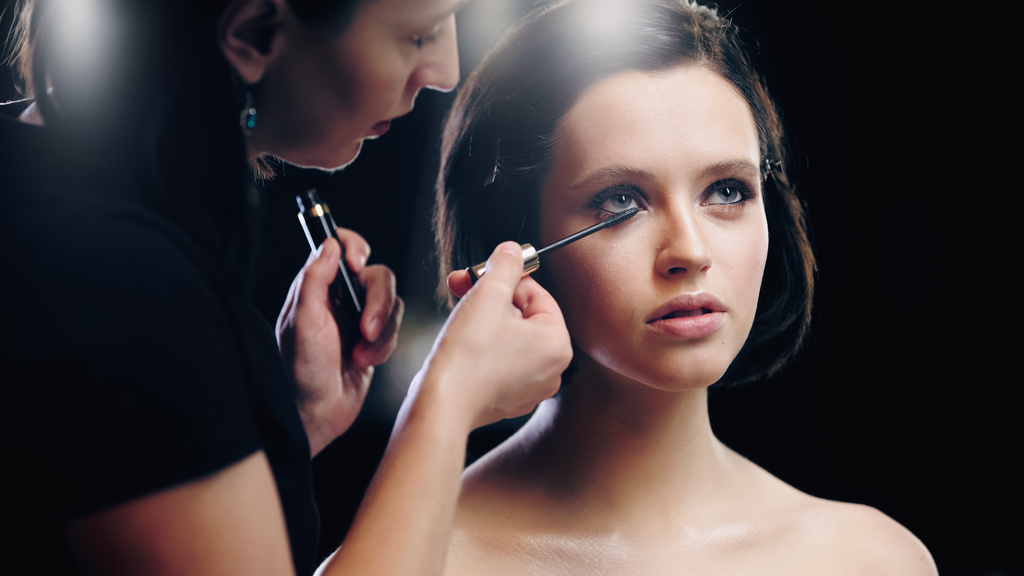 maquillador aplicando rímel en las pestañas del modelo - Foto, imagen