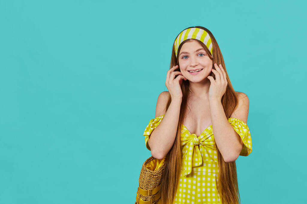 Porträt eines lustigen emotionalen jungen Mädchens auf blauem Hintergrund. Ziemlich überraschte Dame im gelben Kleid posiert im Studio. - Foto, Bild
