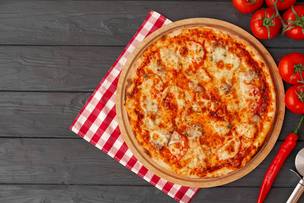Sabrosa pizza sobre fondo de madera negro vista superior - Foto, imagen