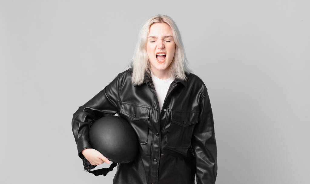 blond pretty woman shouting aggressively, looking very angry. motorbike rider concept - Φωτογραφία, εικόνα