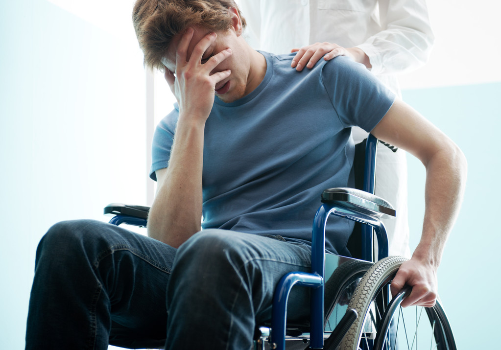 Dottore consolante giovane uomo seduto in sedia a rotelle
 - Foto, immagini