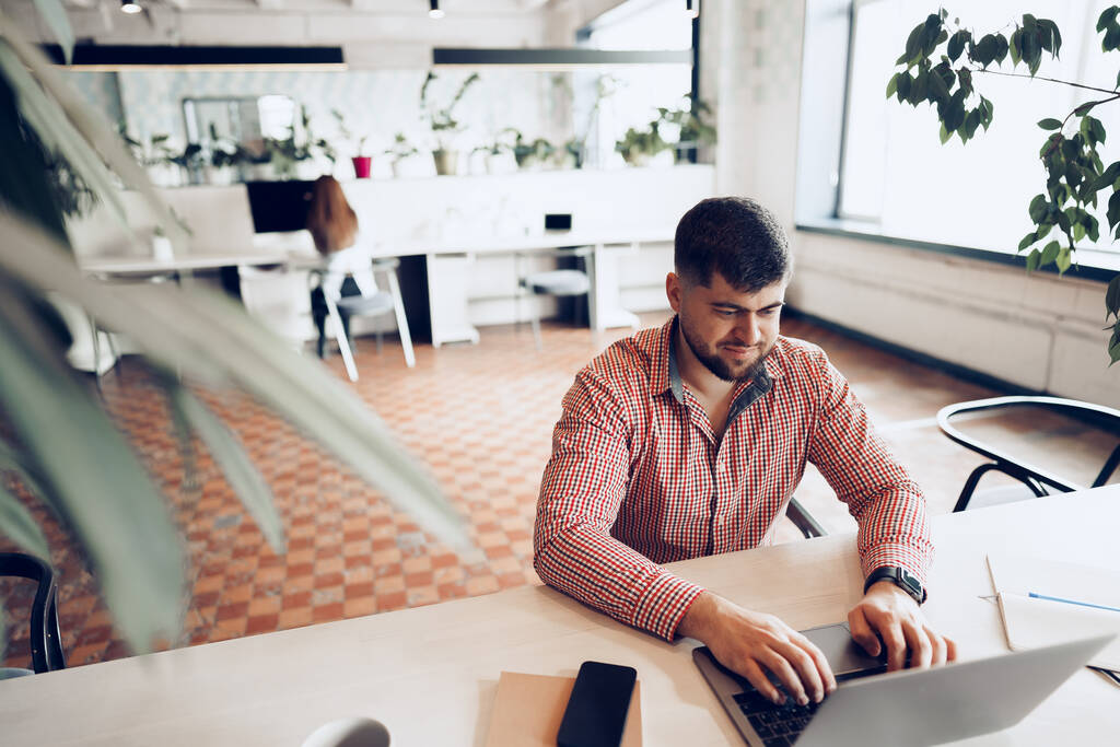 Mladý muž v neformální košili pracuje na počítači v kanceláři - Fotografie, Obrázek