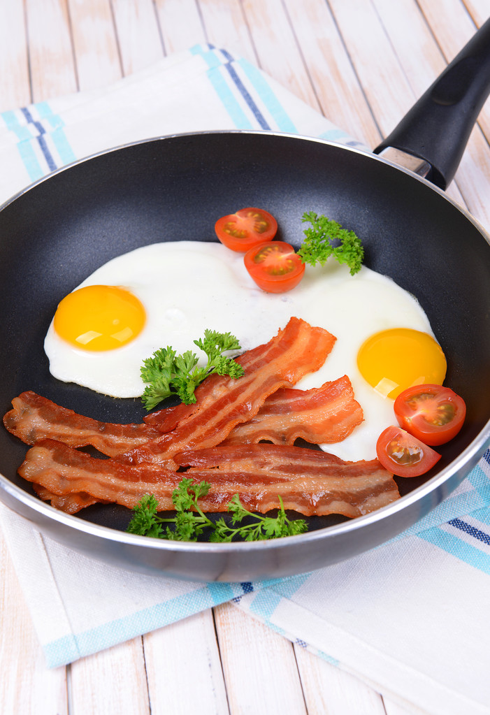ανακατωμένα αυγά και μπέικον στο τηγάνι σε κοντινό πλάνο του πίνακα - Φωτογραφία, εικόνα