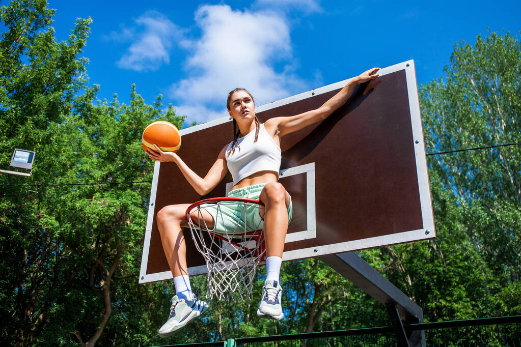 młoda piękna brunetka dziewczyna pozowanie na boisku do koszykówki - Zdjęcie, obraz