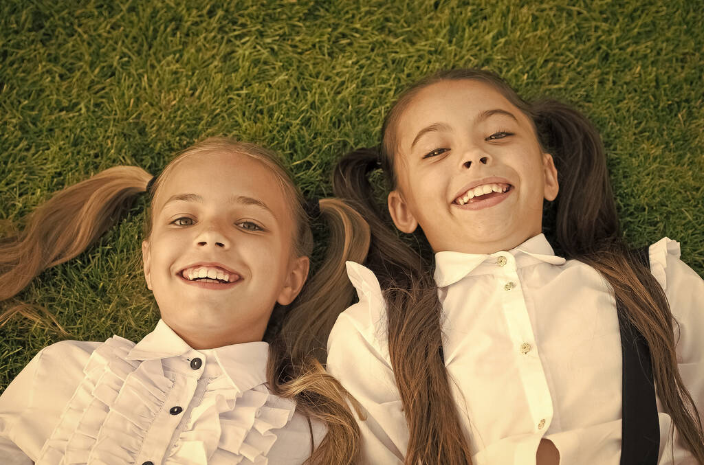 Счастливого детства. Счастливые дети отдыхают на зеленой траве. Наслаждаюсь детскими годами. Защита детства. Детский центр. Детское счастье. Международный день защиты детей - Фото, изображение