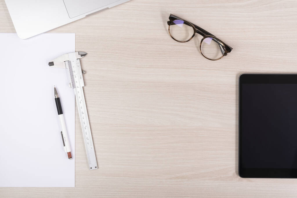A top view üzletember munkahely papírok, toll, vernier caliper, tabletta és szemüveg - Fotó, kép