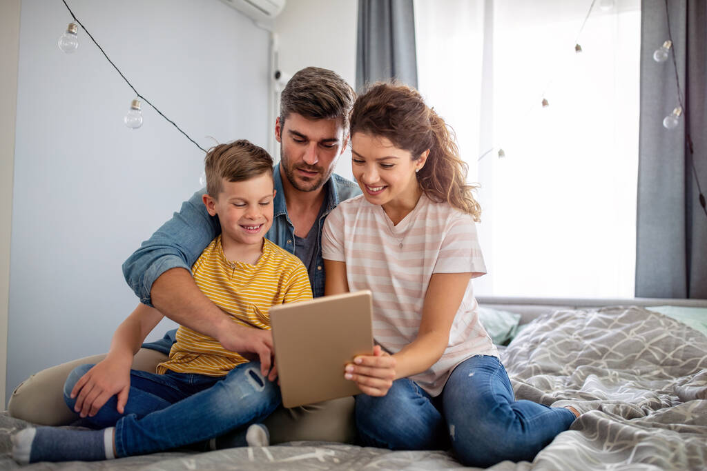 Boldog család használ technológiai eszközök együtt otthon. Emberek, oktatási koncepció. - Fotó, kép