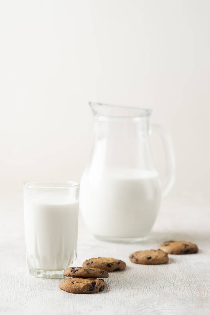 Süt ve çikolata parçalı kurabiyeler beyaz ahşap arka plan fotokopi alanı üzerinde. - Fotoğraf, Görsel