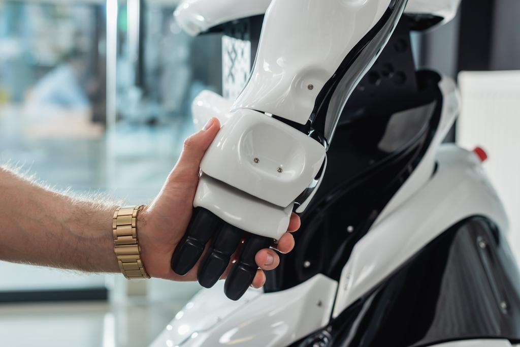 visão parcial do empresário segurando a mão do robô  - Foto, Imagem