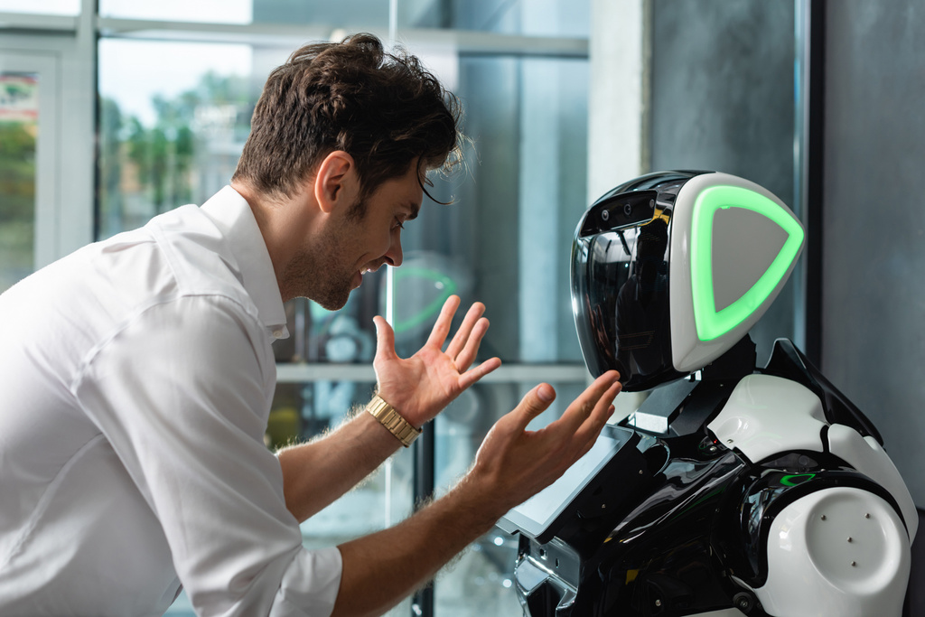 excited businessman showing wow gesture near humanoid robot in office - Photo, Image
