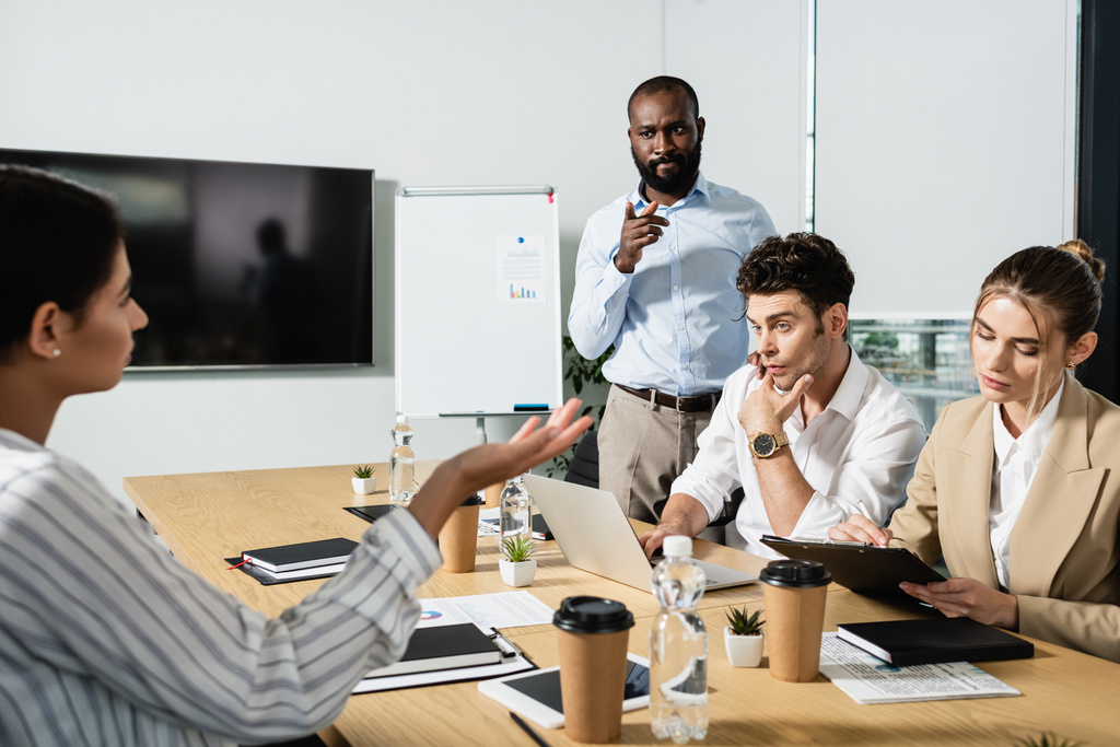 thoughtful african american businessman pointing with finger during meeting with coworkers - Photo, Image