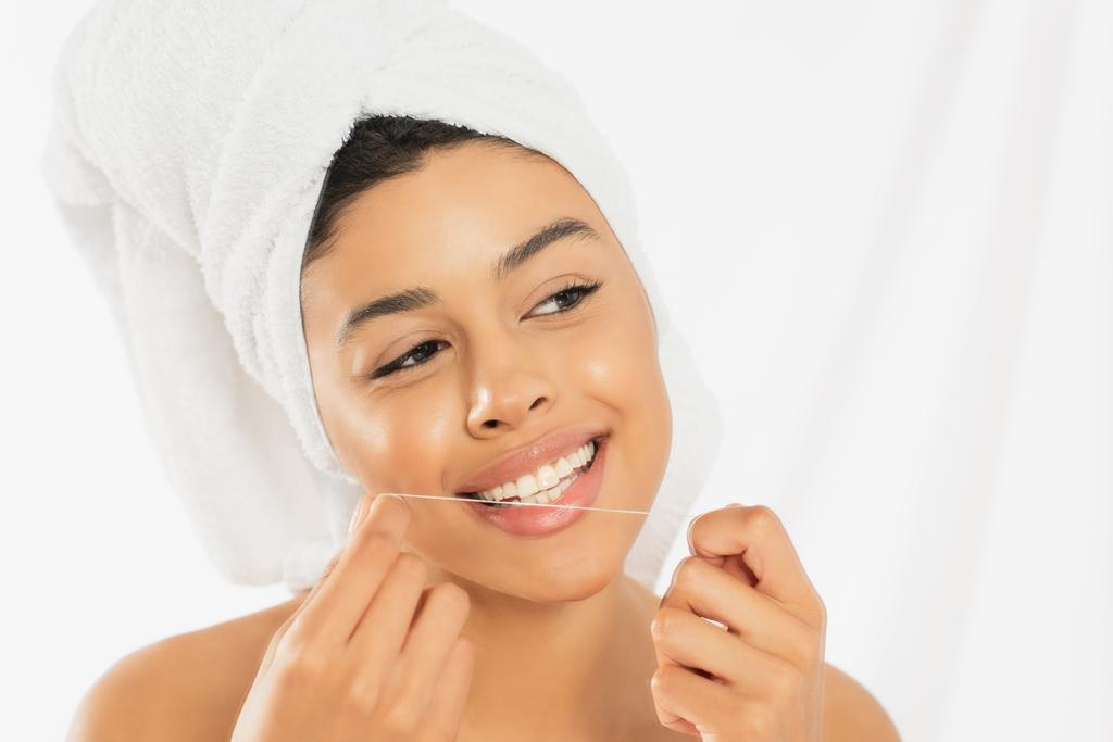 young african american woman wrapped in towel cleaning teeth with dental floss on white background - Photo, Image