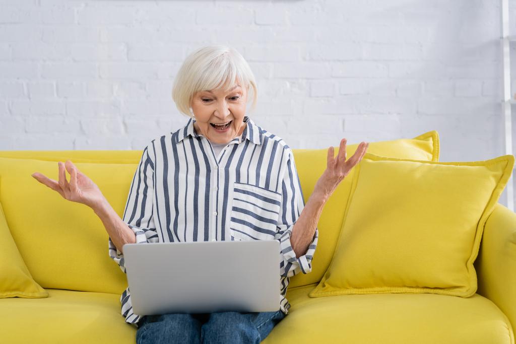 Mulher surpreendida usando laptop na sala de estar  - Foto, Imagem