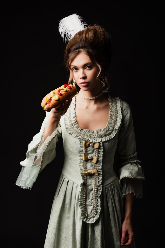 tyylikäs nainen pastelli harmaa vintage mekko tilalla maukas hot dog eristetty musta - Valokuva, kuva