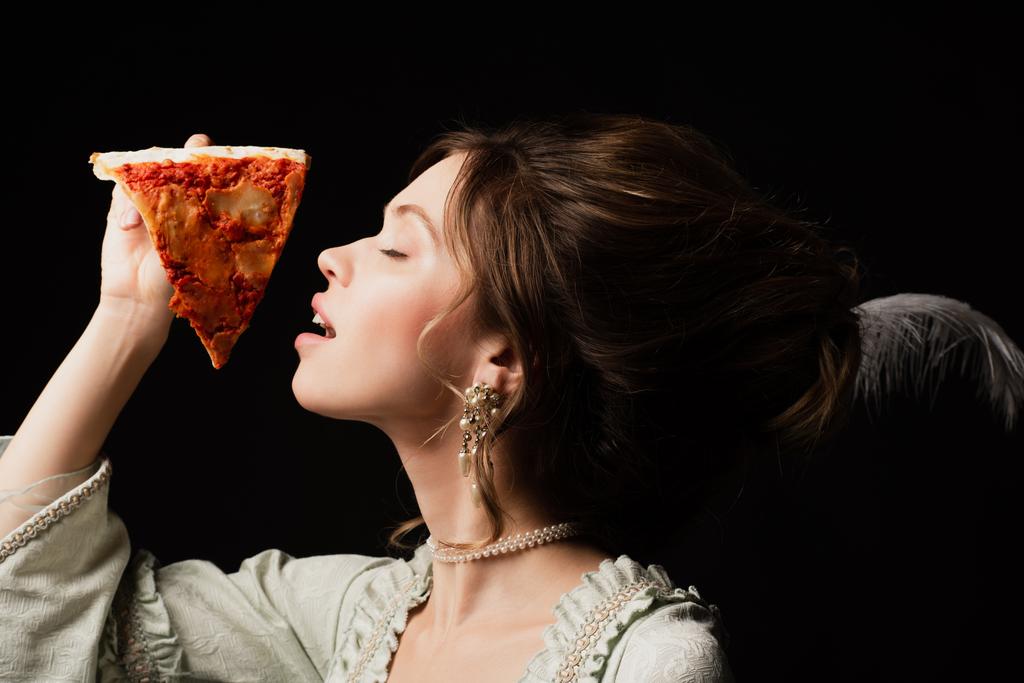érzéki vintage stílusú nő csukott szemmel tartja finom pizza elszigetelt fekete - Fotó, kép