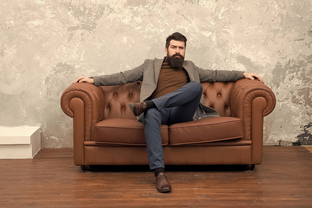 Hombre relajante en lujoso sofá de cuero, concepto de estilo clásico - Foto, imagen
