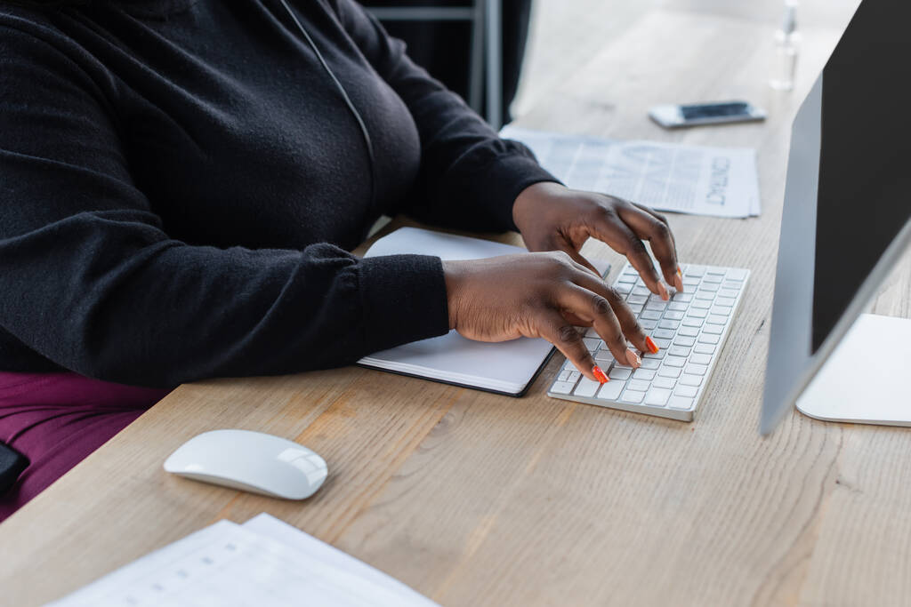 částečný pohled na africkou americkou podnikatelek psaní na klávesnici počítače v kanceláři  - Fotografie, Obrázek