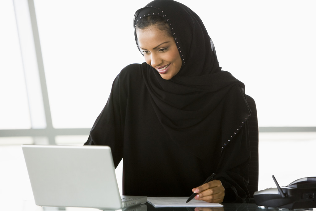 Uma empresária do Oriente Médio usando um laptop
 - Foto, Imagem