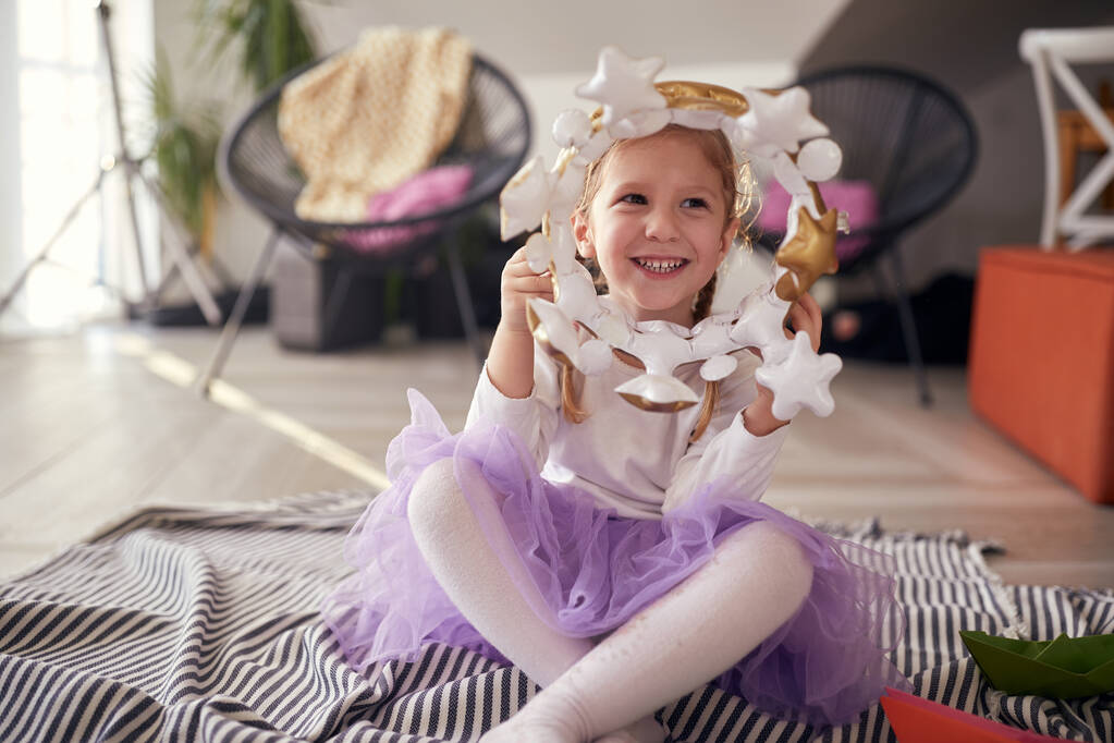 Uma menina brincando no chão em um ambiente descontraído em casa. Brincar, infância, casa - Foto, Imagem