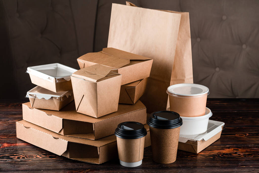 set eco tableware for food delivery craft. Eco craft paper tableware. Paper cups, dishes, bag, fast food containers, box for delivery food on wooden background. Recycling concept. Zero waste, plastic-free and eco-friendly living - Photo, Image