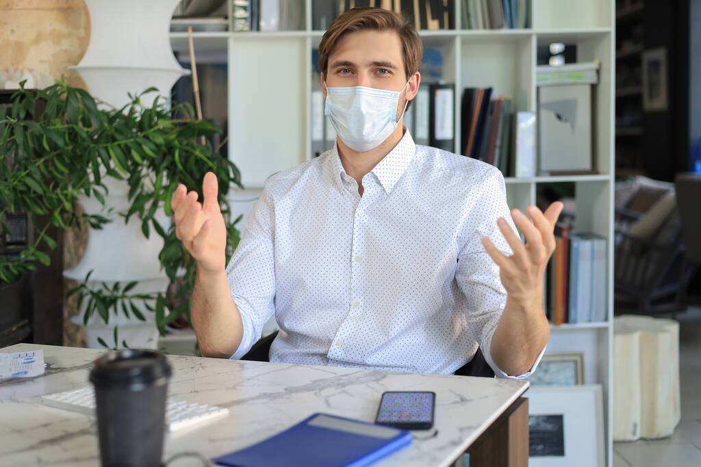 Podnikatel pracuje v preventivní lékařské masce v úřadu - Fotografie, Obrázek