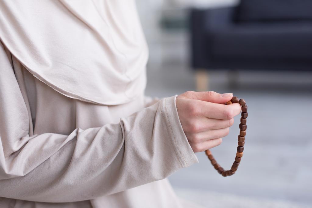 partial view of muslim woman with rosary praying at home - Photo, Image