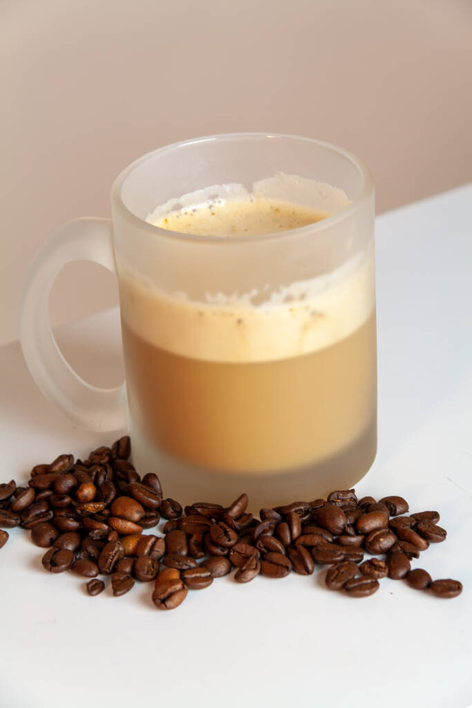 カプチーノとコーヒー豆のカップのクローズアップショット - 写真・画像