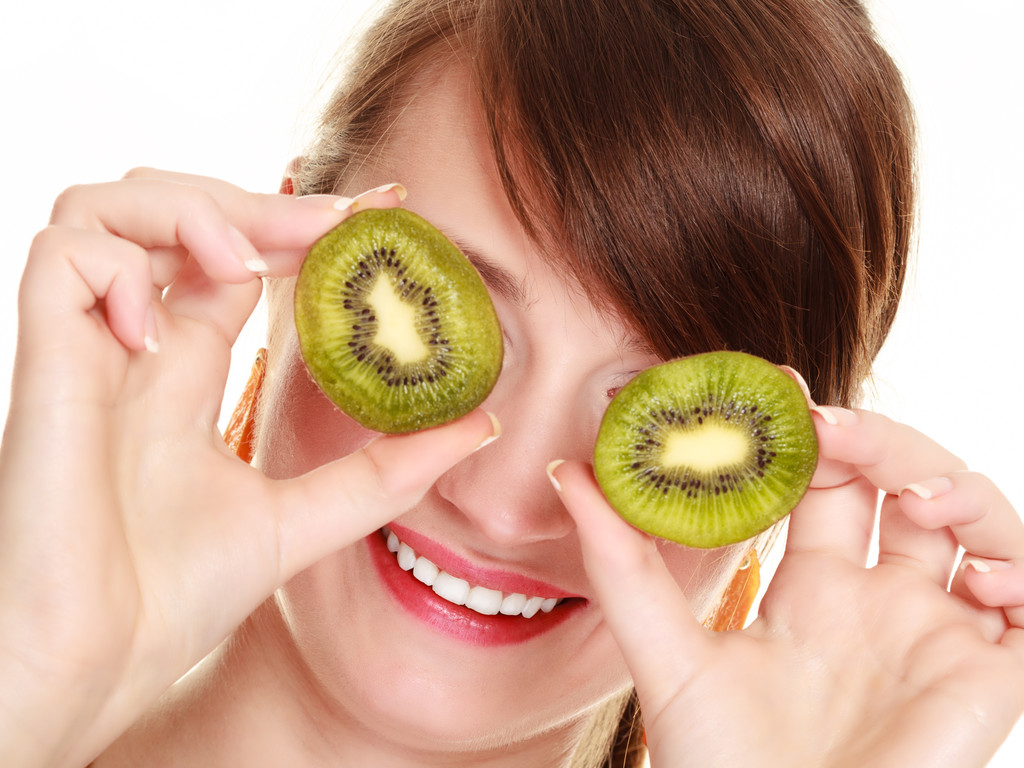 Ragazza che copre gli occhi con kiwi frutta tropicale
 - Foto, immagini