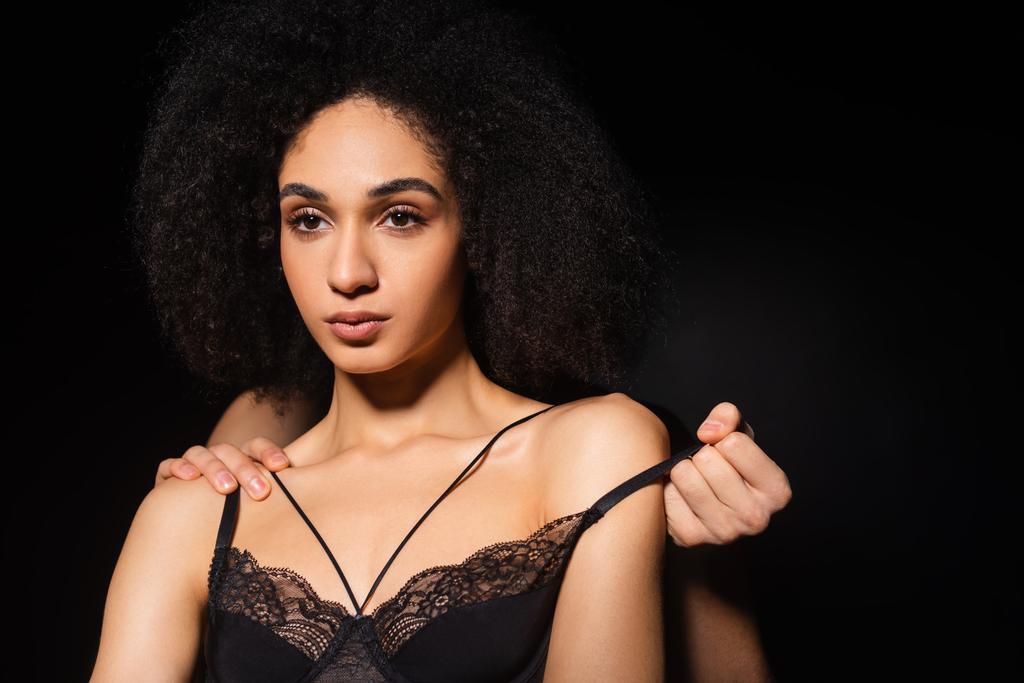 Man taking off lace bra from african american woman isolated on black  - Photo, Image