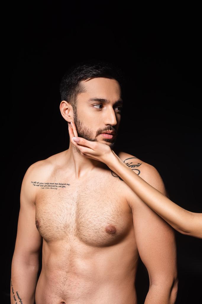 Woman touching beard of tattooed boyfriend isolated on black  - Photo, Image