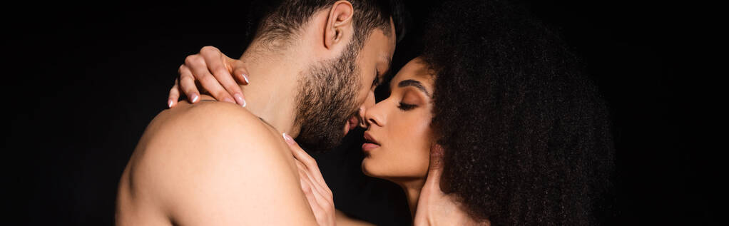 Side näkymä paidaton mies suutelee afrikkalainen amerikkalainen tyttöystävä eristetty musta, banneri  - Valokuva, kuva